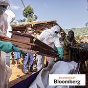 Health workers place the body of a suspected Ebola victim into a coffin outside a family home in the community of Mongbwalu.