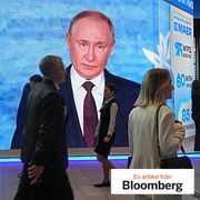 People walk past a screen with an image of Russian President Vladimir Putin at the St. Petersburg International Economic Forum, 2026.
