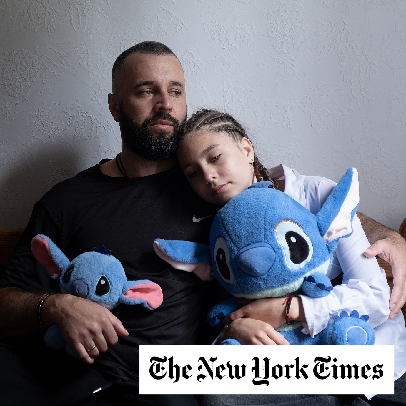 Yevhen and his daughter Veronika holding Stitch toys that belonged to her sister, Milana.