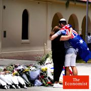 A couple lay flowers at a tribute to shooting victims outside the Bondi Pavilion at Sydney's Bondi Beach on Monday, a day after a shooting.