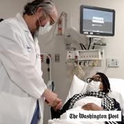 Pig kidney recipient Towana Looney is visited by Dr. Robert Montgomery of NYU Langone Health, center, on Dec. 10, 2024, at NYU Langone Health, in New York City.