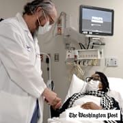 Pig kidney recipient Towana Looney is visited by Dr. Robert Montgomery of NYU Langone Health, center, on Dec. 10, 2024, at NYU Langone Health, in New York City.