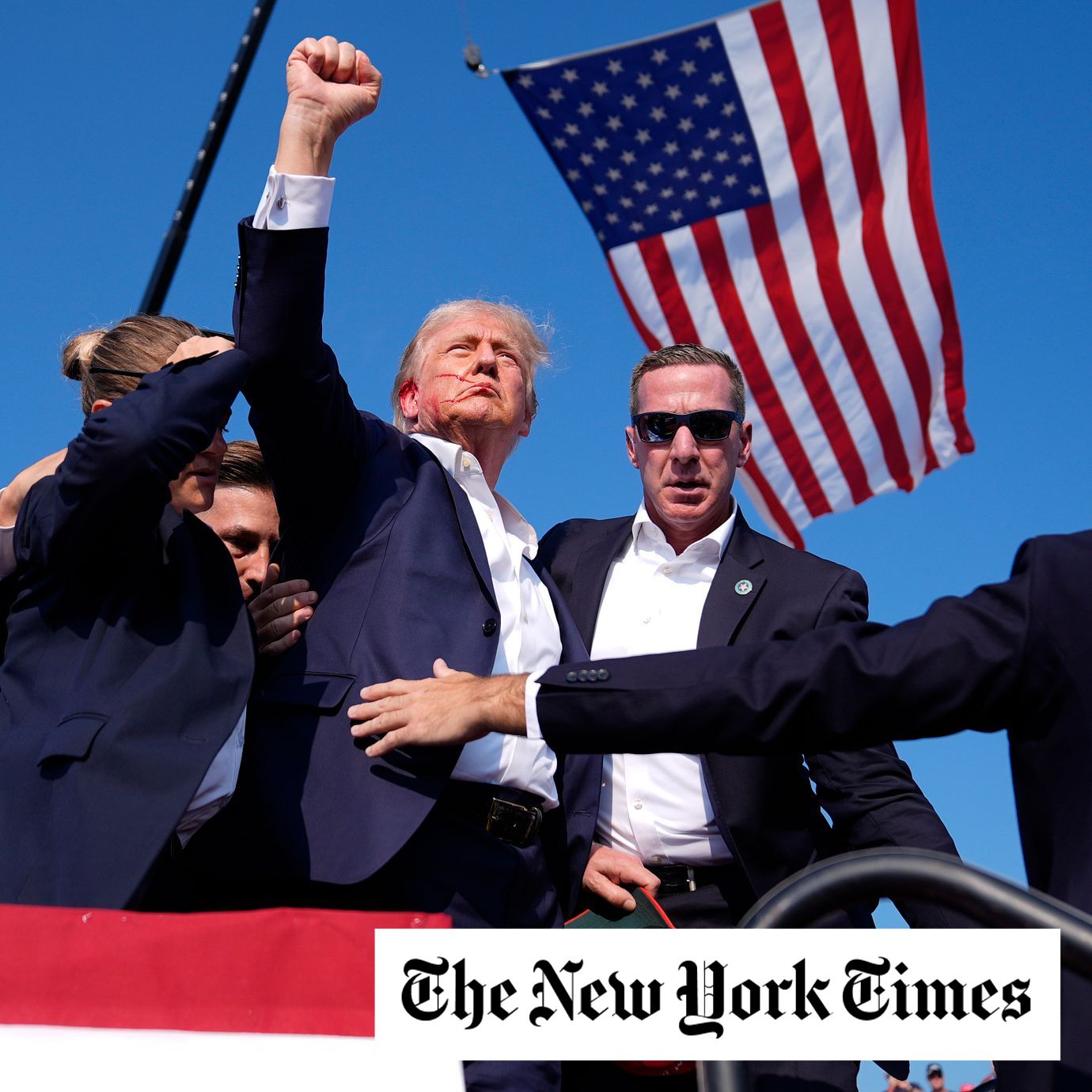 Republican presidential candidate former President Donald Trump gestures as he is surrounded by U.S. Secret Service agents as he leaves the stage.