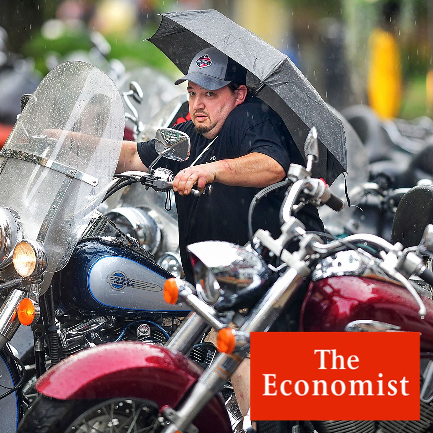 Jeramie Moore, of Johnstown, Pa., tries to avoid the rain as he takes off on his Harley-Davidson during Thunder in the Valley event on Main Street in Johnstown, Pa., June 23, 2023.