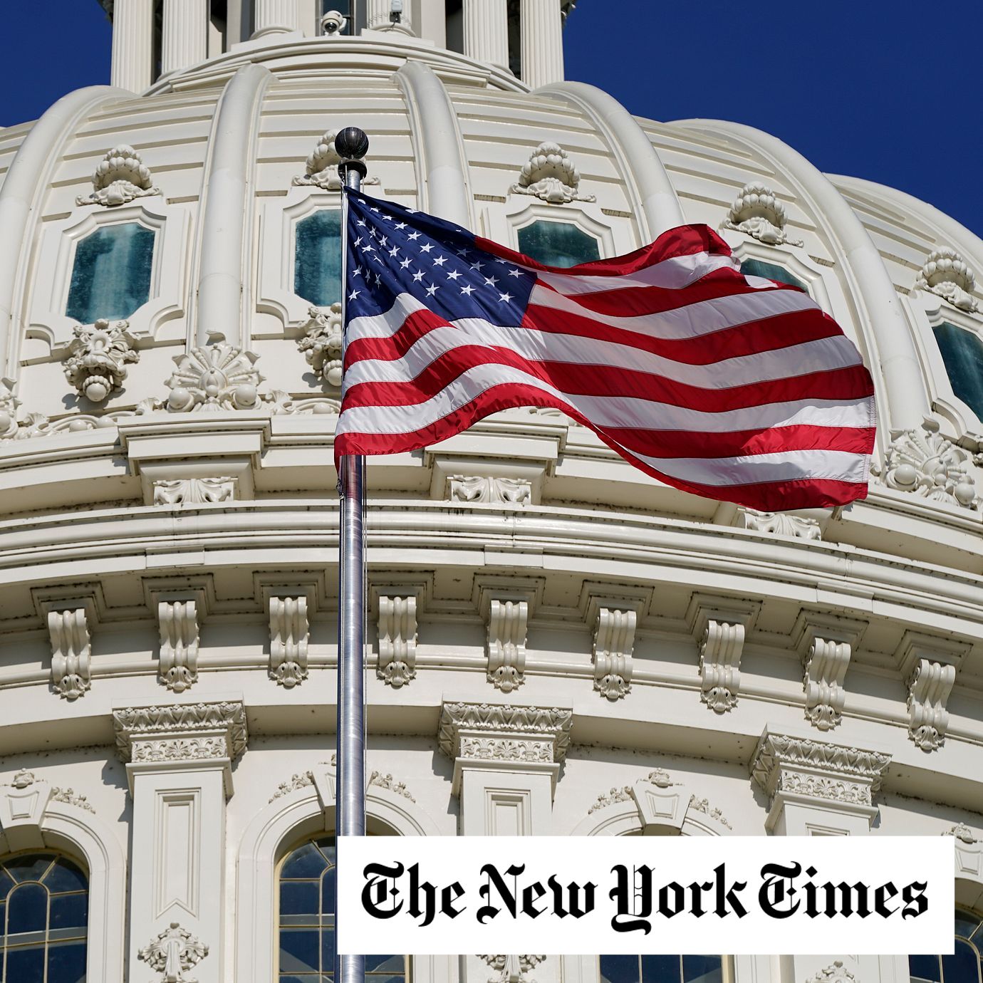An American flag waves below the U.S. Capitol dome.
