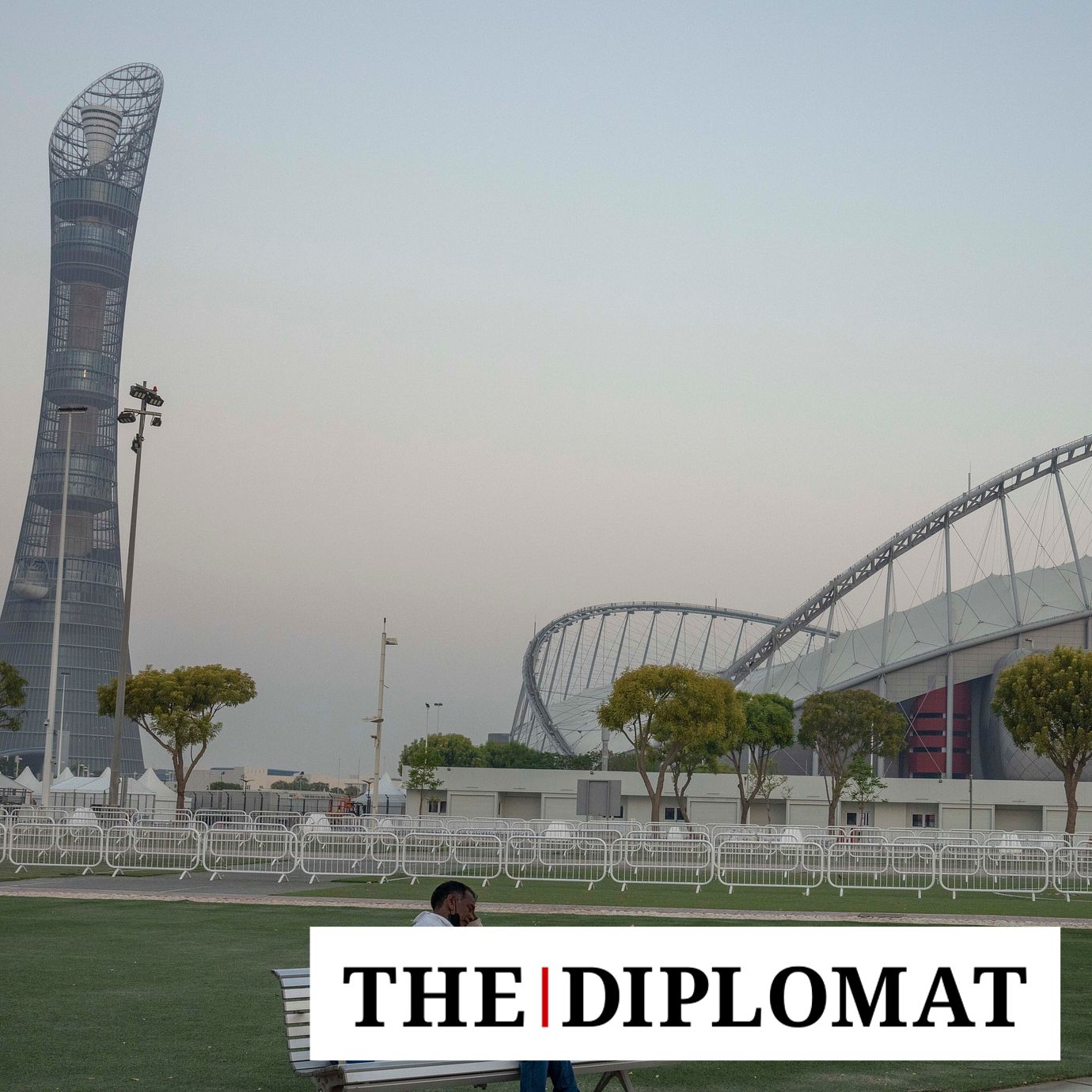 A migrant worker sleeps on a bench before his early morning shift, in front of Khalifa International Stadium, also known as Qatar's national and oldest stadium, which will host matches during FIFA World Cup 2022, in Doha, Qatar, Saturday, Oct. 15, 2022.