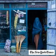 An Afghan woman wearing a burka exits a small shop in Kabul, Afghanistan, Sunday, Dec. 5, 2021.