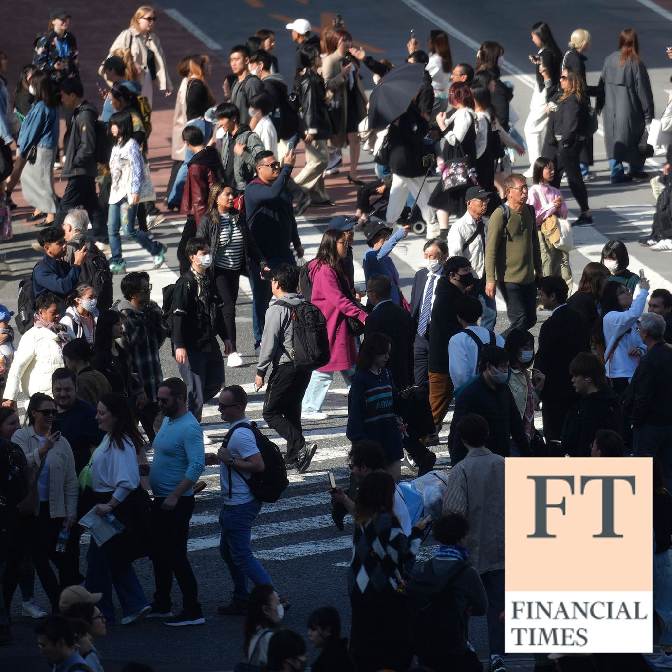 People walk a pedestrian crossing in Shibuya district in Tokyo.